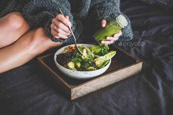 Healthy vegan bowl on tray and woman eating - Stock Photo - Images