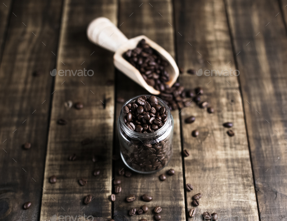 coffee beans in a jug and wooden scoop