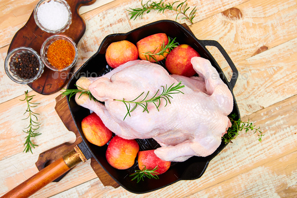 Whole raw chicken in skillet or iron pan