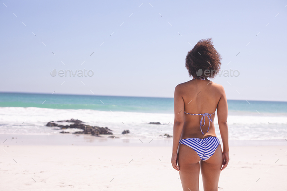 Rear view of mixed race woman in bikini standing on the beach