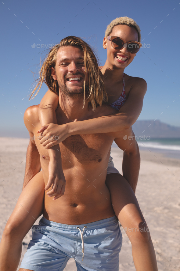 Free Photo  Man giving piggyback ride to woman on the beach