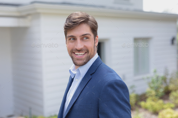 Portrait of happy Caucasian businessman looking away in the garden