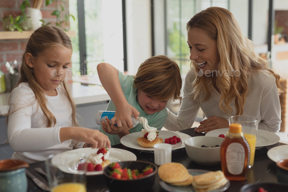 Caucasian family having food at dining table in a comfortable home ...