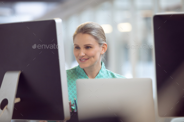 Front view of beautiful Caucasian female executive working on computer at desk in office