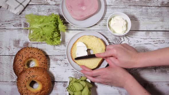 Spreading cream cheese on the bagel alt