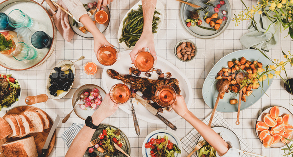 Peoples hands clikning with wineglasses over table with snacks - Stock Photo - Images