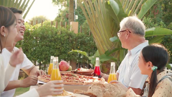 Asian retirement grandfather, pretty granddaughter, and parents enjoying eating pizza together alt