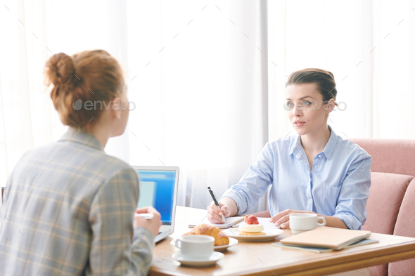 Modern ladies discussing project over lunch - Stock Photo - Images