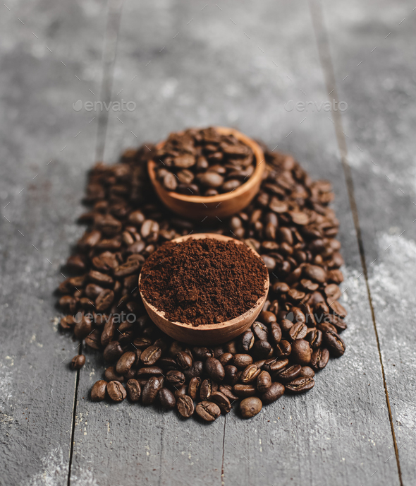 ground coffee in wood saucer with grunge black background