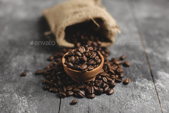 coffee beans in wood saucer and bag with grunge black background