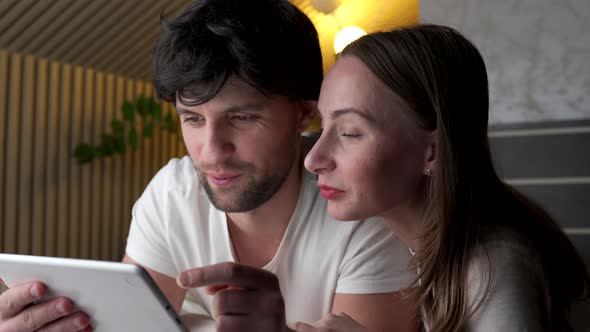 Young Couple Using Tablet on Bed in Bedroom Late at Night alt