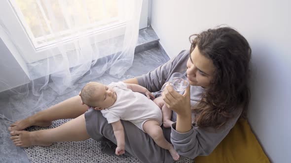 Mother Makes Photos Sleeping Baby on Knees