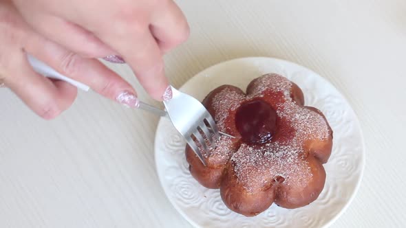 A Woman Cuts A Donut With Jam In Powdered Sugar. Donuts In The Form Of A Flower. Close Up. alt