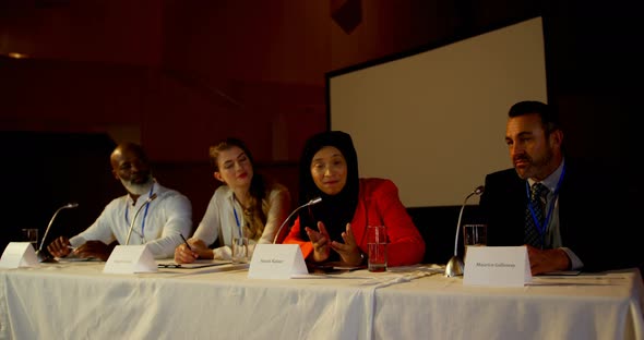 Mature hijab businesswoman speaks in business seminar in auditorium 4k alt