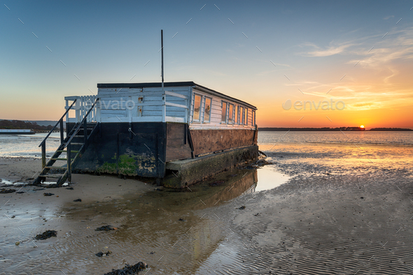 Sunset over an old wooden houseboat on the shore of Bramble Bush - Stock Photo - Images