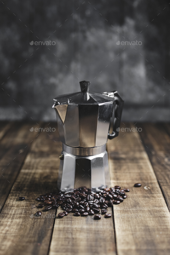 coffee beans and moka pot on wood background