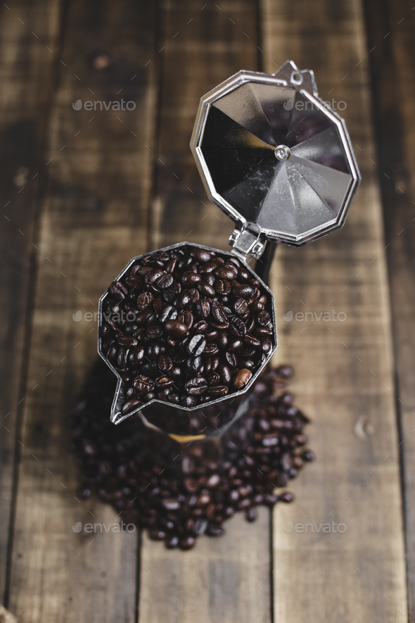 coffee beans and moka pot on wood background