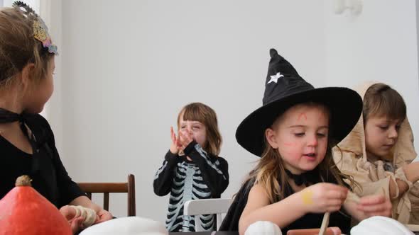 Happy Little Kids in Halloween Suits Have Fun at Home Party alt