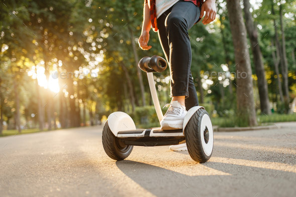 Young male person riding on gyroboard in park - Stock Photo - Images