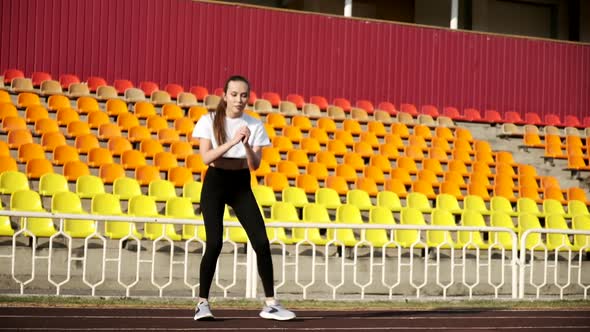 Young Slim Asian Brunette Female in Sportswear Does Sports Exercises at Stadium