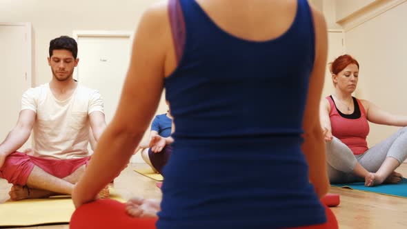 Instructor assisting a group of people in yoga alt