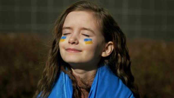 Girl 910 Years Old with the Ukrainian Flag on Her Shoulders
