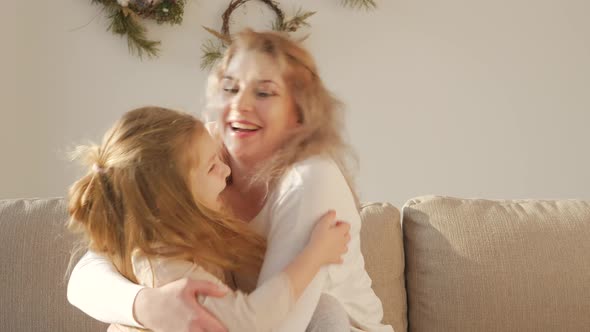 Happy affectionate family single mum and cute little child daughter embracing bonding laughing toget alt