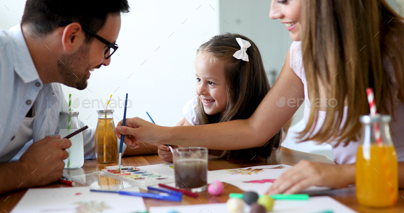 Mom and dad drawing with their daughter