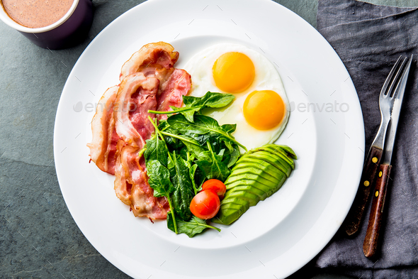 Ketogenic diet breakfast. fried egg, bacon and avocado, spinach and bulletproof coffee