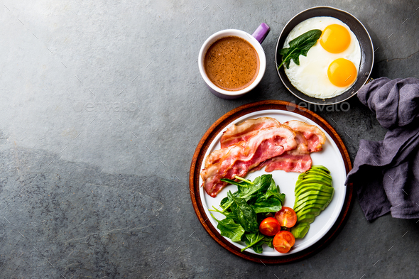 Ketogenic diet breakfast. fried egg, bacon and avocado, spinach and bulletproof coffee