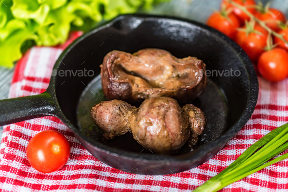 Tasty roasted chicken giblets in pan - Stock Photo - Images