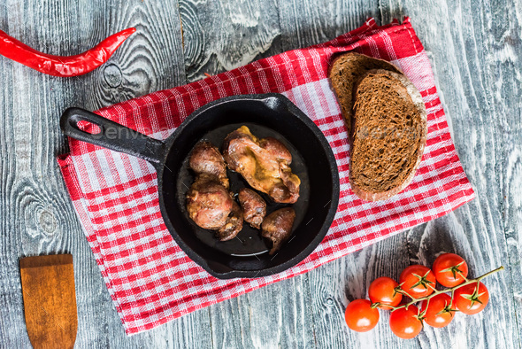 Top view roasted chicken giblets in pan and bread - Stock Photo - Images