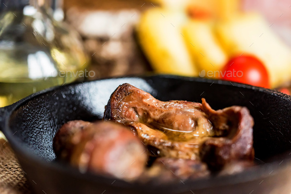 Tasty roasted chicken giblets in pan - Stock Photo - Images