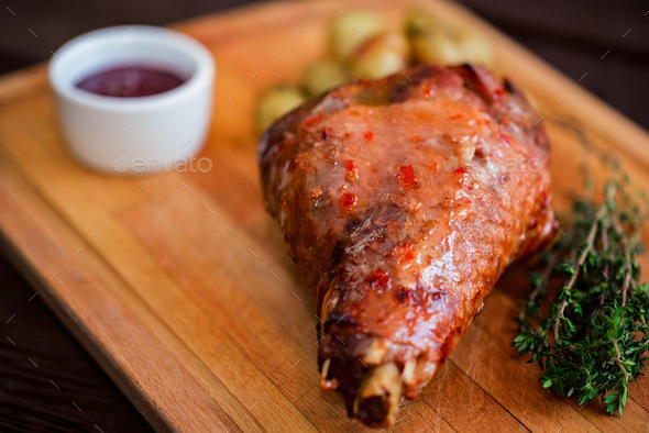 Close up roasted turkey filet with spices, vegetables and jam on wooden board