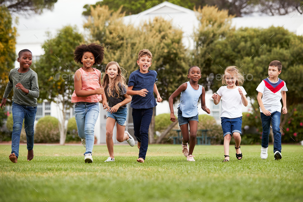 Excited Elementary School Pupils Running Across Field At Break Time ...