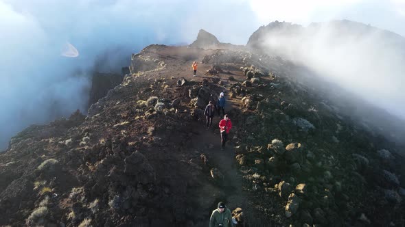 Drone footage of people walking on the summit of the Piton des Neiges at the Reunion island. alt