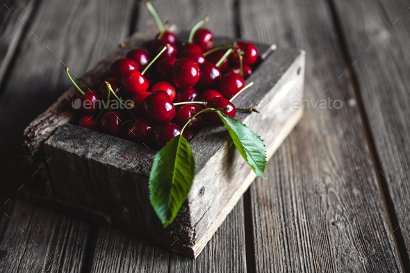 Cherries in a wood crate over a wood background in an old wooden box, healthy food, fruit