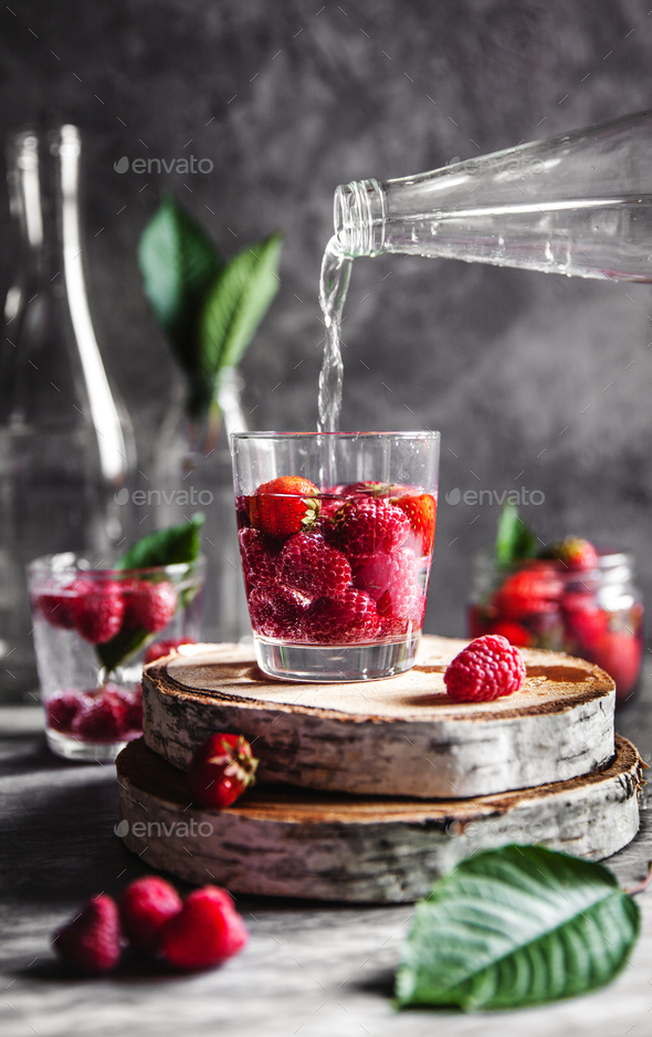 Strawberries in water on a dark gray background. Healthy food, fruit. A bouquet of flowers