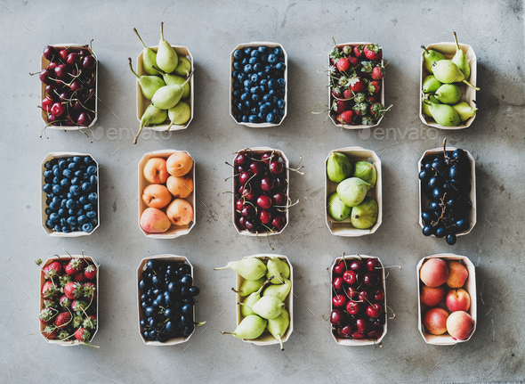 Flat-lay of fresh fruits and berries over grey concrete background - Stock Photo - Images