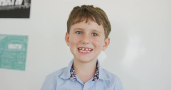 Video of happy caucasian boy standing in class during lessons alt