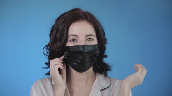 Young caucasian beautiful woman put on protective face medical mask.Female in pandemic epidemic.