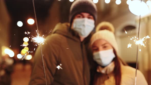 Unrecognizable Couple Hands Holding and Waving Sparklers Christmas Eve or Xmas