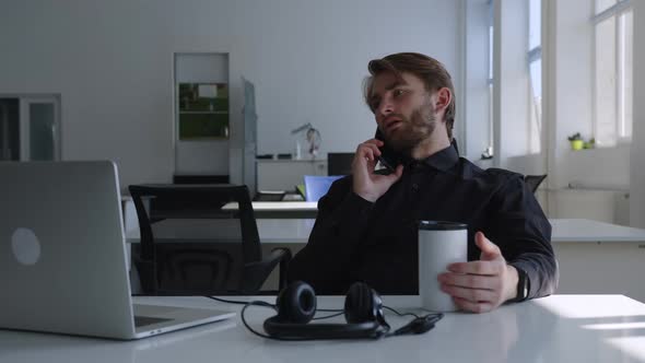 Man Sits and Talks on His Phone Black Shirt alt
