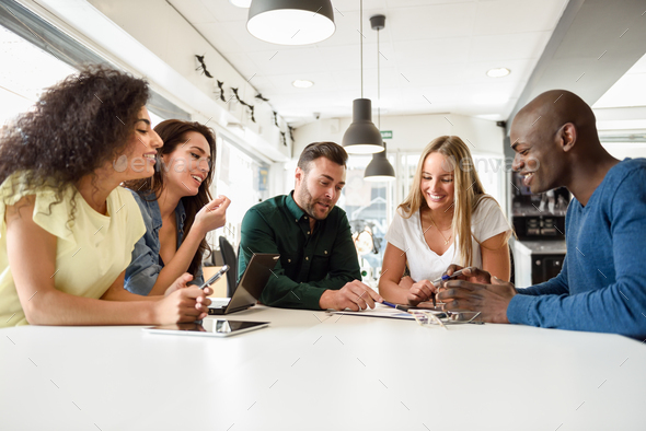 Multi-ethnic group of young people studying together on white desk - Stock Photo - Images