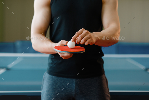 Male person holds racket and ping pong ball on it