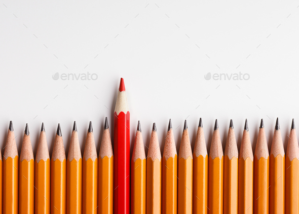 One red pencil standing out of line with similar ones