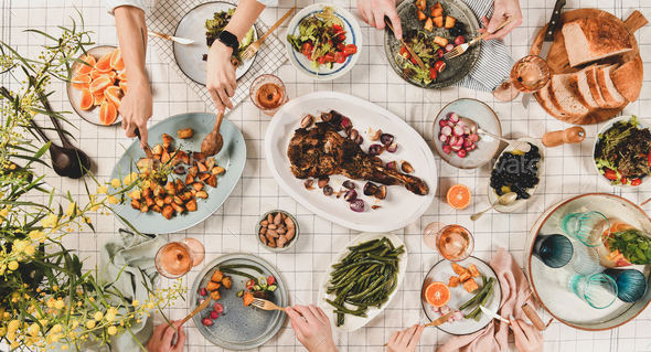 Peoples hands over table with meat, salads, wine, wide composition - Stock Photo - Images