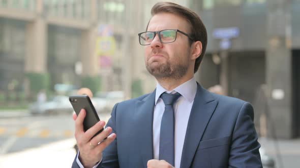 Portrait of Businessman having Loss while using Smartphone, Outdoor alt