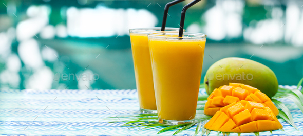 Fresh Tropical Fruit Smoothie Mango Juice and Fresh Mango on a Outdoor  Tropical Background. Stock Photo by annapustynnikova