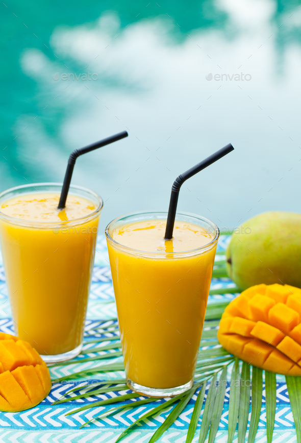 Fruit Smoothie Mango Juice and Fresh Mango on a Outdoor Tropical Background.  Copy Space. Stock Photo by annapustynnikova
